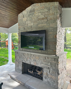 TV mounted on an outdoor covered patio fireplace
