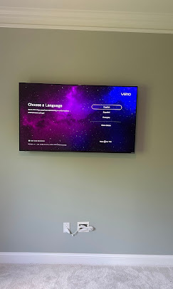 TV mounted on a brick fireplace in a bright great room