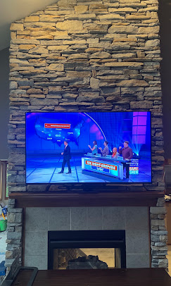 TV mounted on an exterior brick patio wall